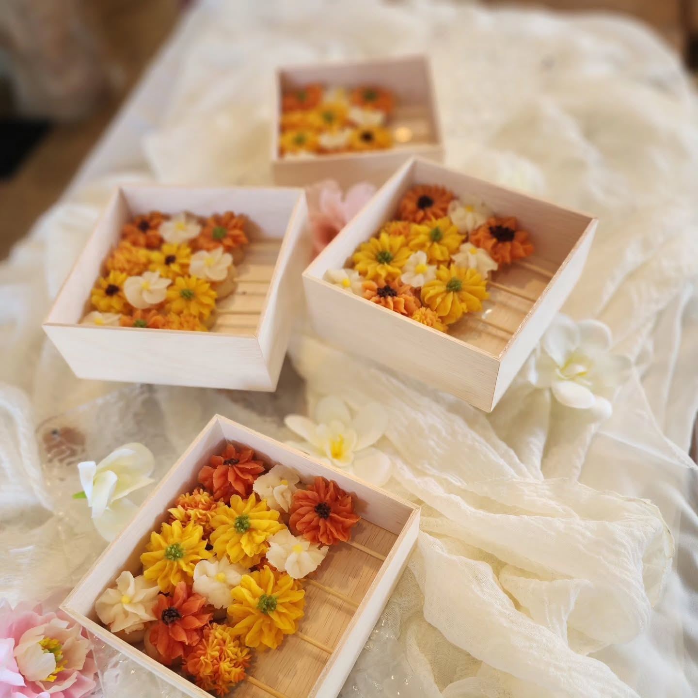 木の箱に並ぶ黄色やオレンジ色のあんこのお花作品